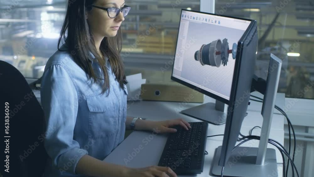 Female Industrial Engineer Works on 3D Turbine/Engine Model in CAD Software on Her Desktop Computer. Inside of the Factory is Seen From Her Office Window. Shot on RED EPIC-W 8K Helium Cinema Camera. Female Industrial Engineer Works on 3D Turbine/Engine Model in CAD Software on Her Desktop Computer. Inside of the Factory is Seen From Her Office Window. Shot on RED EPIC-W 8K Helium Cinema Camera.