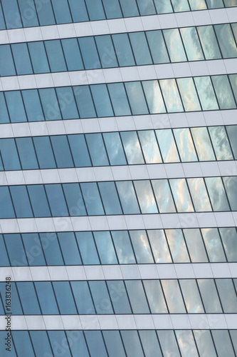 Vertical background of glass reflecting blue sky