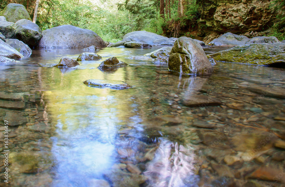 Fototapeta premium Large stones on a mountain river with clear blue water.Carpathians