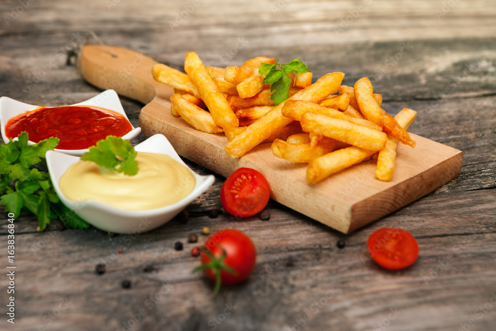French fries with cherry tomato on table French fries with cherry tomato on table