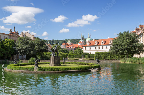 Pool, statue and building at the Wallenstein (Waldstein) Garden (Valdstejnska Zahrada). It's a public Baroque garden at Lesser Town in Prague, Czech Republic. St. Nicholas Church is in the background.
