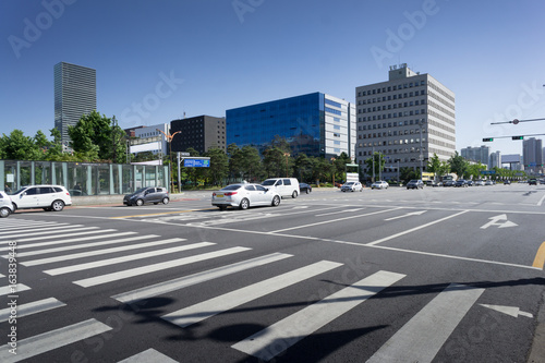 Empty pedestrian crossing in a large modern city under blue sky. Seoul, South Korea photo