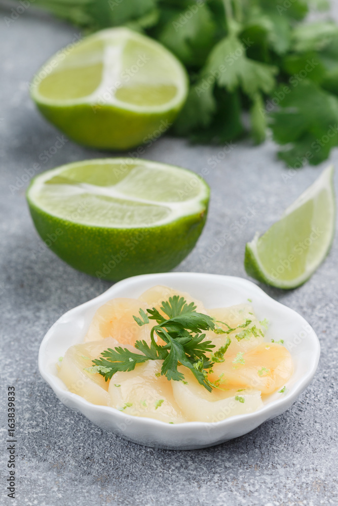 Scallops with lime and cilantro. Delicious appetizer of seafood. Carpaccio. Sashimi. Selective focus Scallops with lime and cilantro. Delicious appetizer of seafood. Carpaccio. Sashimi. Selective focus