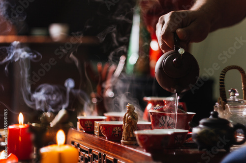 Tea ceremony. The man pours hot water into the chinese tea cup