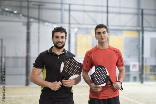 Paddle tennis couple ready for match posing for picture