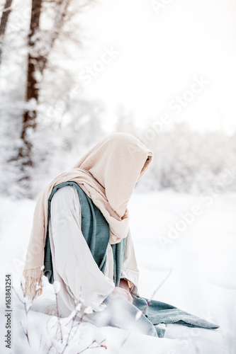 Jesus Christ kneels in the snow to pray