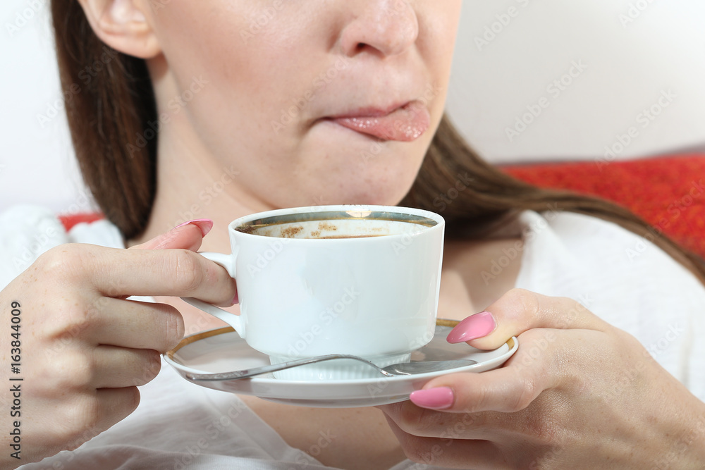 Girl drinking hot chocolate and lick one's lips Girl drinking hot chocolate and lick one's lips