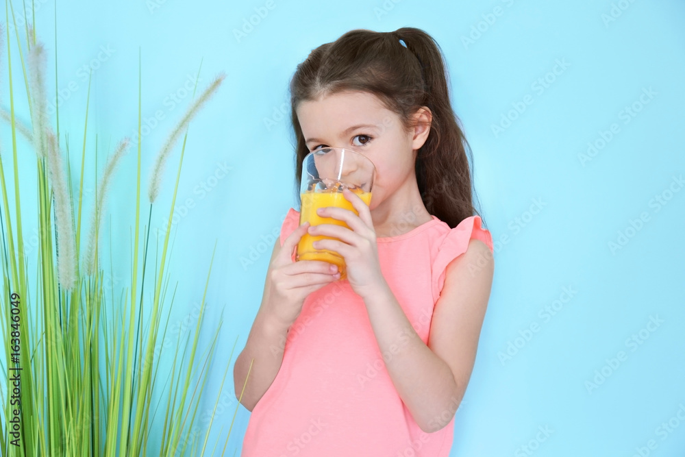 Cute little girl drinking juice on color background Cute little girl drinking juice on color background