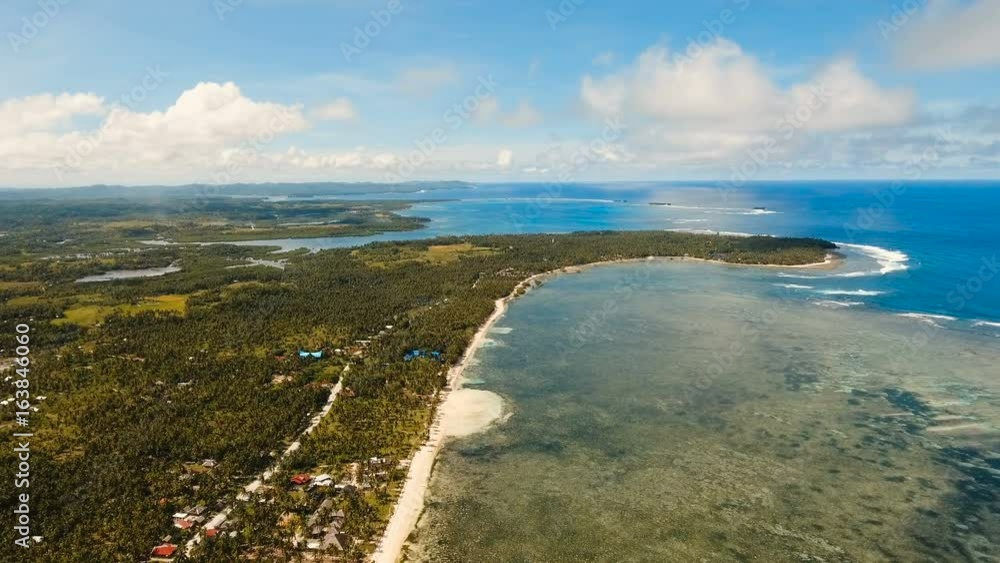 Beautiful tropical island with sand beach, palm trees. Aerial view of tropical beach on the island Siargao, Philippines. Tropical landscape: beach with palm trees. Seascape: Ocean, sky, sea Beautiful tropical island with sand beach, palm trees. Aerial view of tropical beach on the island Siargao, Philippines. Tropical landscape: beach with palm trees. Seascape: Ocean, sky, sea