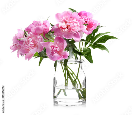 Glass vase with beautiful peonies on white background