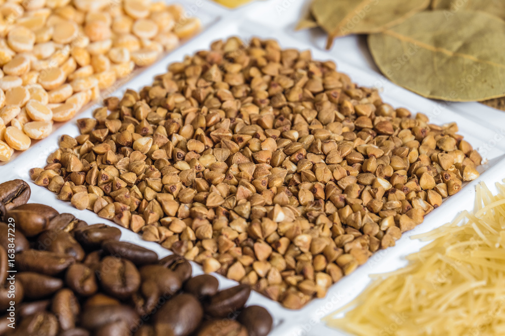 Buckwheat grains close-up in set of groceries. Food product background with limited depth of field. Buckwheat grains close-up in set of groceries. Food product background with limited depth of field.