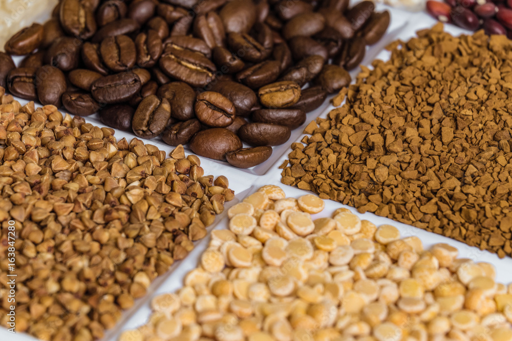 Set of groceries laying horizontal perspective with limited depth of field: roasted coffee beans, freeze-dried instant coffee, buckwheat, dried peas.v Set of groceries laying horizontal perspective with limited depth of field: roasted coffee beans, freeze-dried instant coffee, buckwheat, dried peas.v