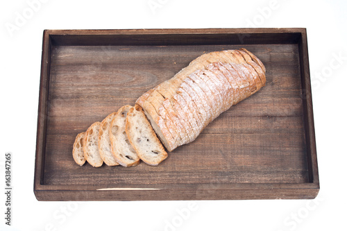 Sliced crusty ciabatta organic italian bread on wooden vintage tray