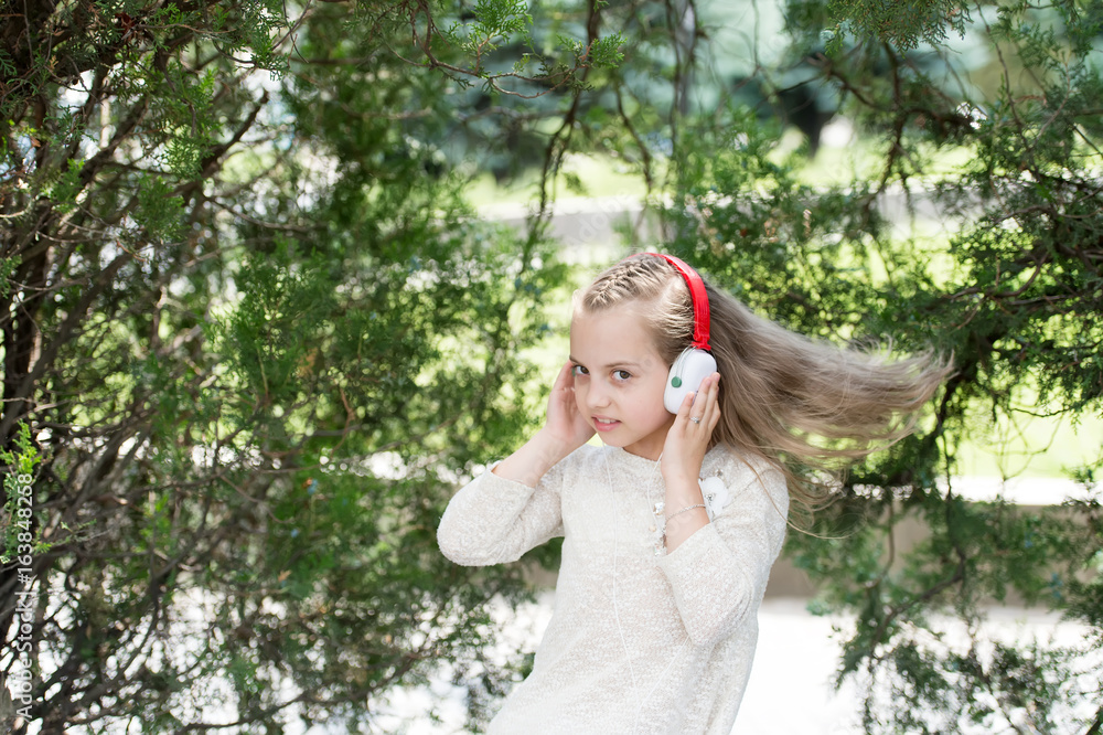 Cute little girl enjoying music using headphones Cute little girl enjoying music using headphones