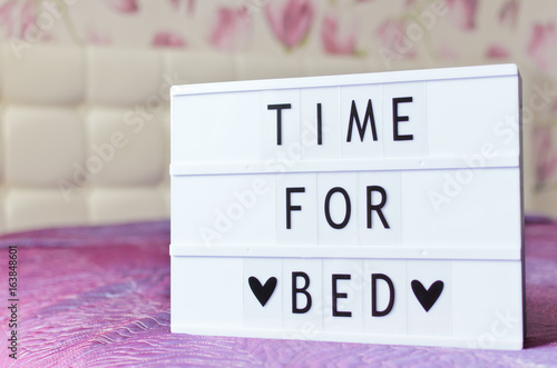 Time for bed sign shown in lightbox in glamour pink bedroom interior