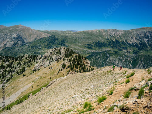 Two hikers ascending mountain in Pyrenees