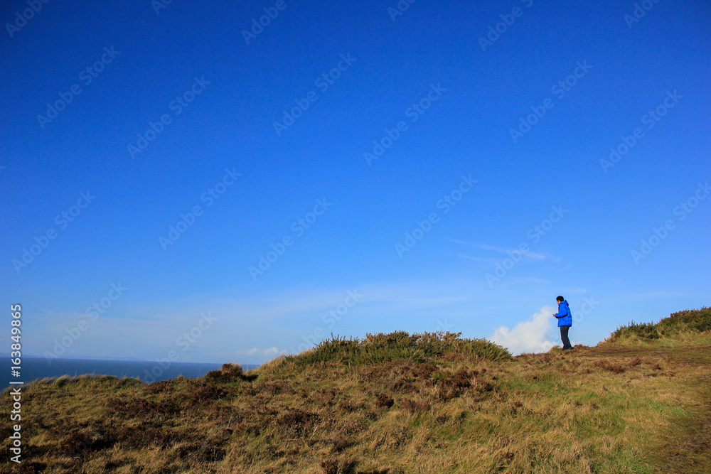 Man at hill top near the ocean