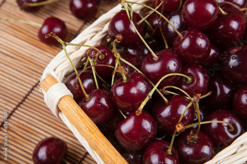 Ripe sweet cherry in the basket on a napkin