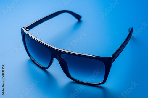 Sunglasses on a blue colored background, summer concept