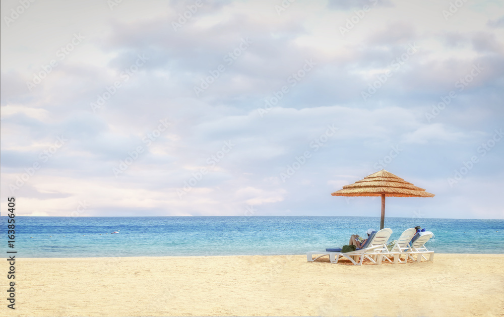 Beach background with lovers on beach chairs