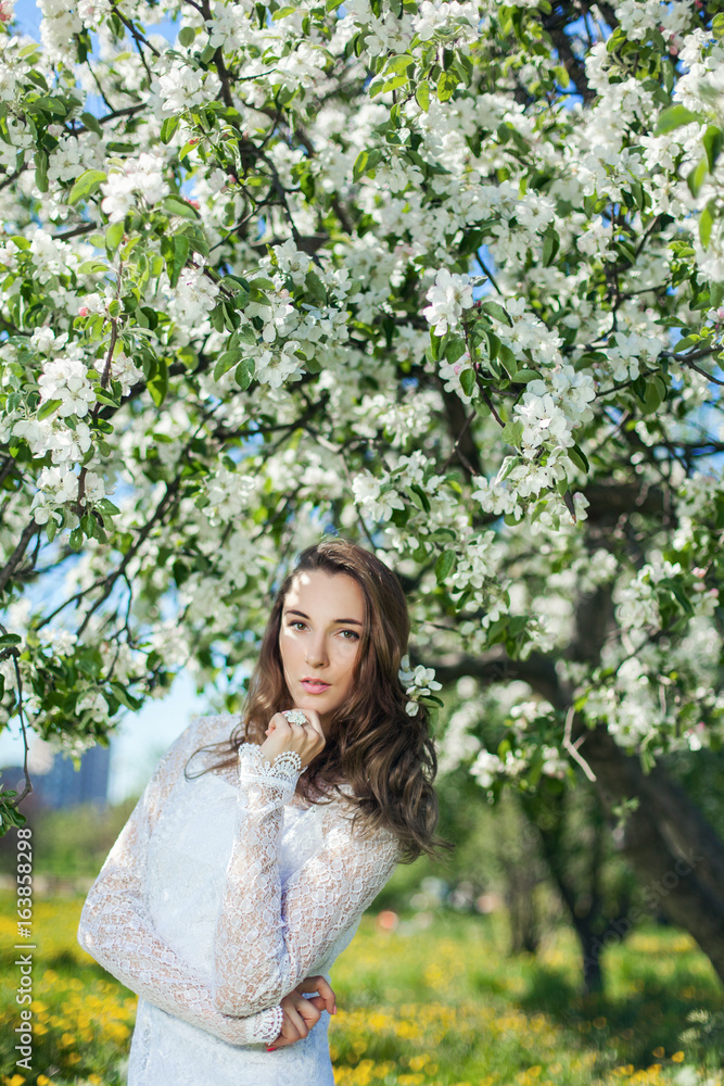 Beautiful brunette posing in blossoming apple-trees Beautiful brunette posing in blossoming apple-trees