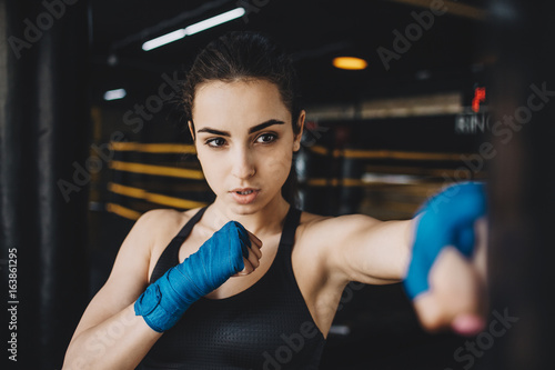 Beautiful and fit female fighter getting prepared for the fight or training © alexshutter95