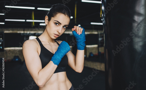 Beautiful and fit female fighter getting prepared for the fight or training