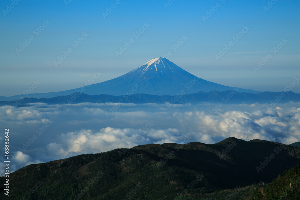 国師ヶ岳から夜明けの雲海に浮かぶ朝焼け富士山