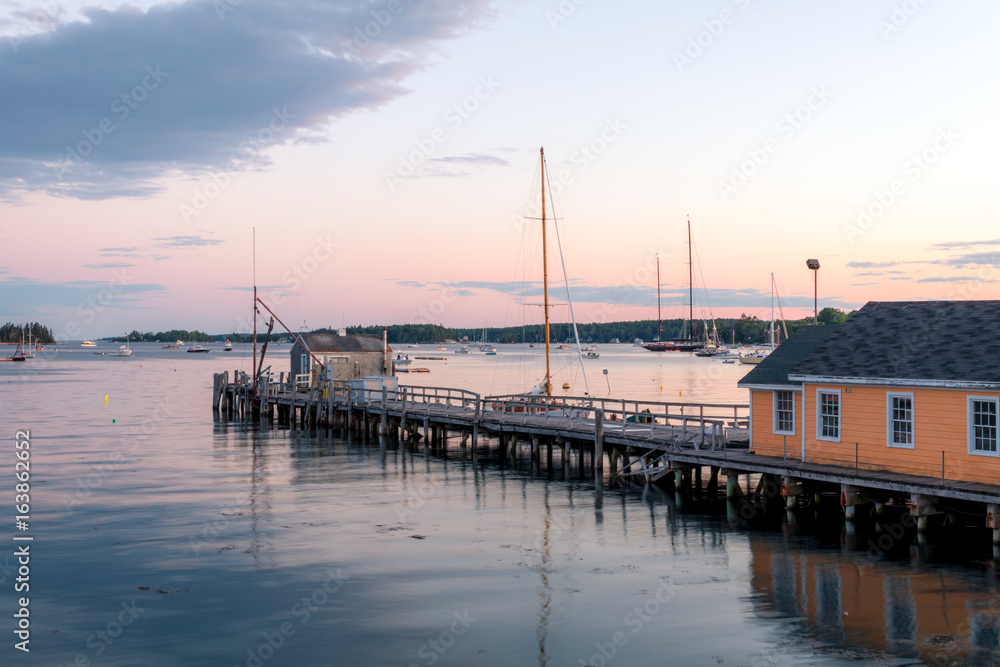 Boathouse and dock in the calm and beautiful Boothbay Harbor at dusk