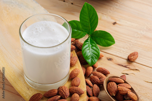 Almond milk with almond on a wooden table