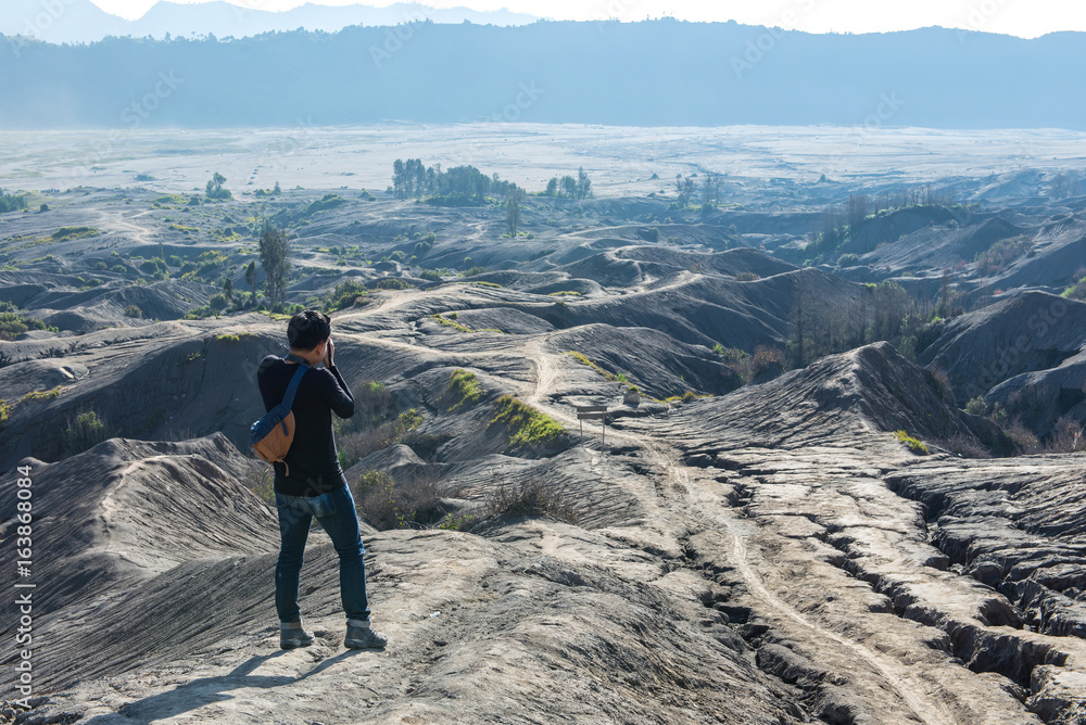 Obraz premium Man on top of Layer Volcanic ash as sand ground of Mount Bromo volcano (Gunung Bromo) at Bromo Tengger Semeru National Park, East Java, Indonesia