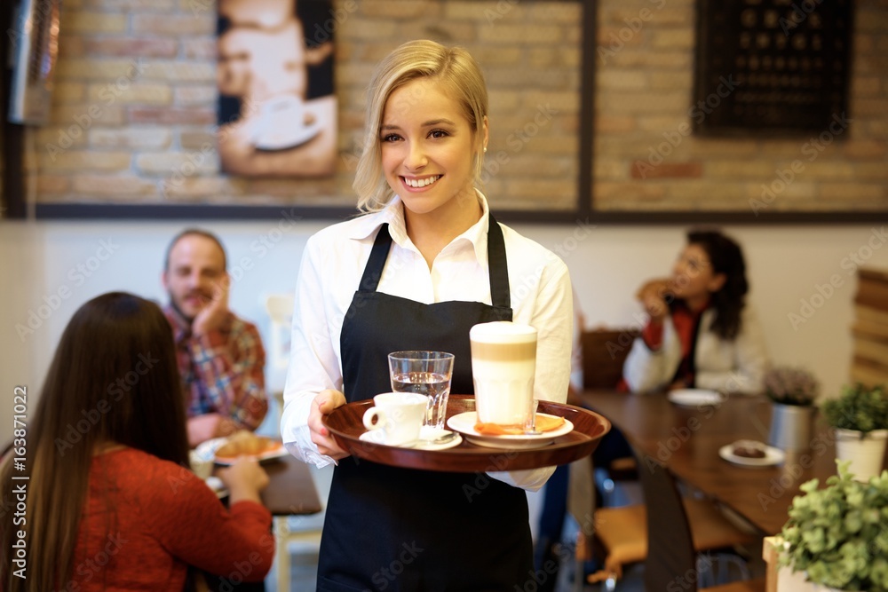 Happy waitress holding tray
