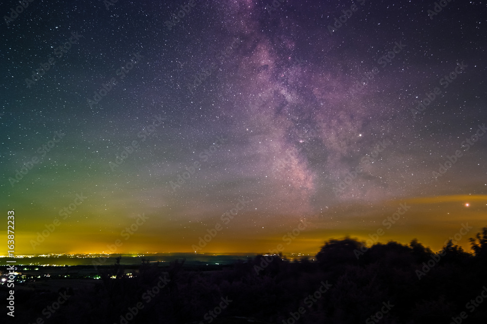 Landscape with the Milky Way as seen from the summit of the mountain Katzenbuckel in the Odenwald in Germany.