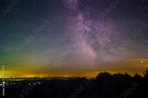 Landscape with the Milky Way as seen from the summit of the mountain Katzenbuckel in the Odenwald in Germany.
