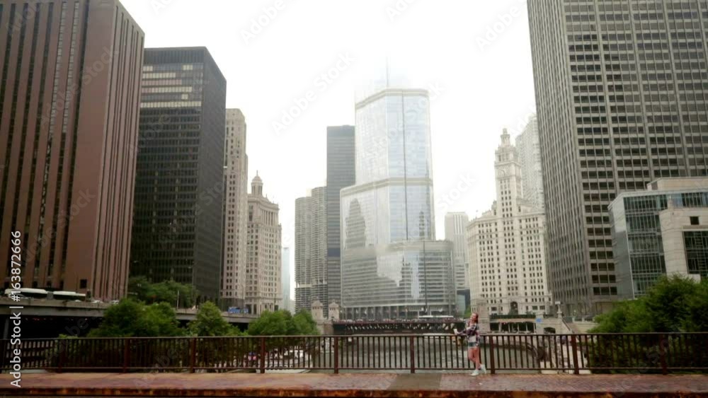 Cityscape. Brunette woman standing on chicago river bridge. Chicago skyline. Beautiful woman standing city river bridge. Modern cityscape. City buildings Cityscape. Brunette woman standing on chicago river bridge. Chicago skyline. Beautiful woman standing city river bridge. Modern cityscape. City buildings