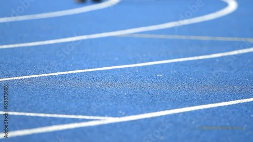 Athlete running on the blue track stadium