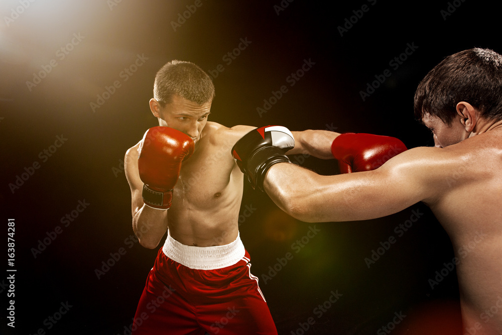 Two professional boxer boxing on black background,