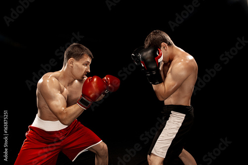 Two professional boxer boxing on black background, © master1305