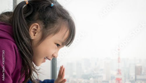 Photography Asian girl is looking out to Tokyo city from windows