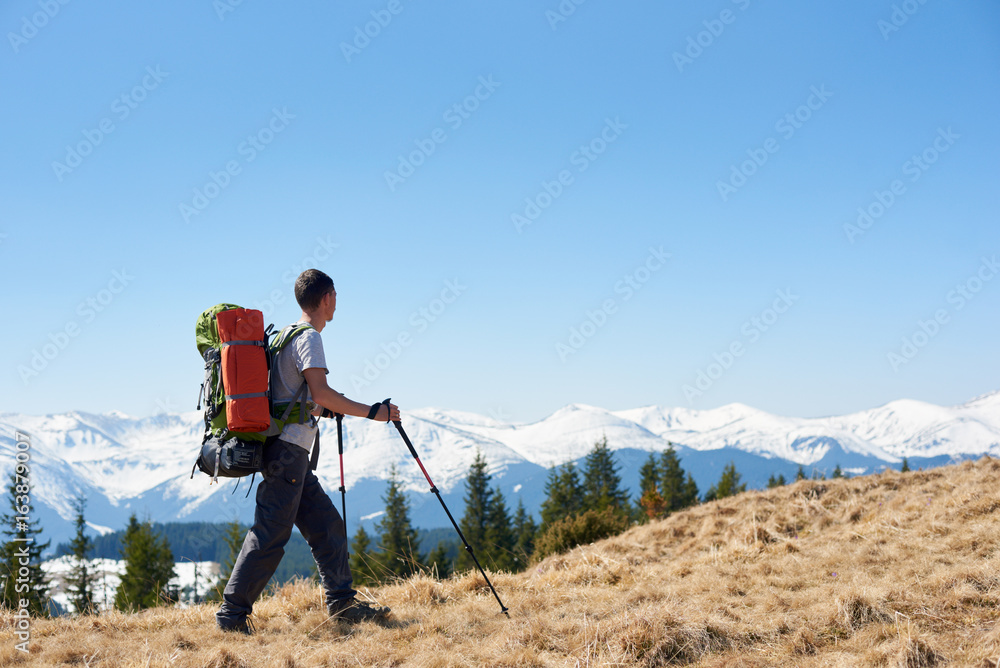 Full length shot of a male backpacker with a backpack hiking in the mountains copyspace landscape view beauty achievement success sport active lifestyle concept