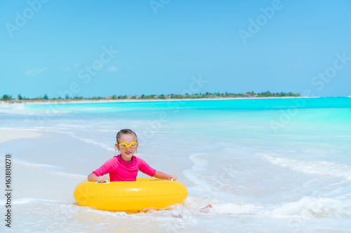 Adorable little girl with inflatable rubber circle splashing. Kid having fun on summer active vacation © travnikovstudio