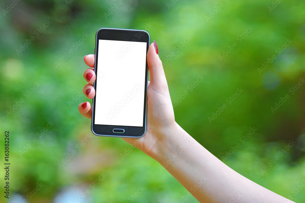 Female hand holding phone with isolated screen on green blurred background