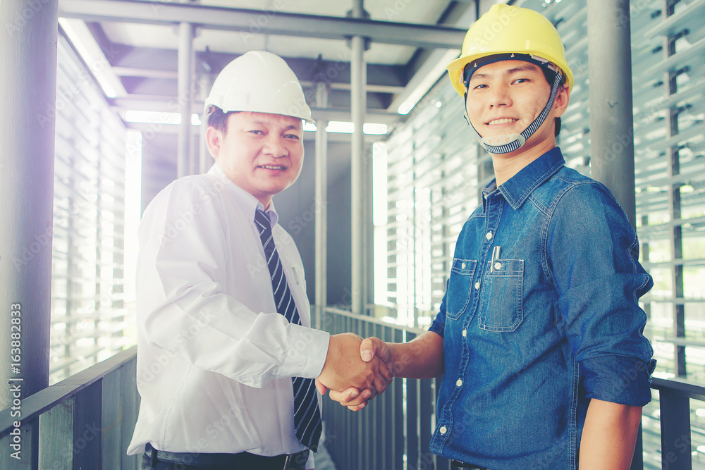 contractor and engineer hand shake while business meeting contractor and engineer hand shake while business meeting