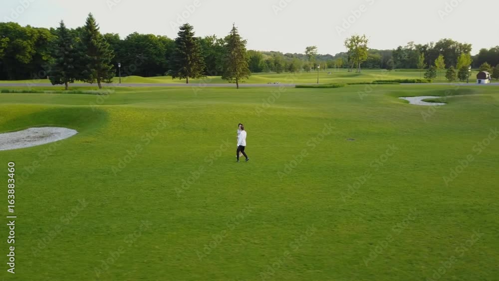 Aerial View Of Young Couple Walking In Summer Park, Circling Drone Shooting Man And Woman Outdoors Aerial View Of Young Couple Walking In Summer Park, Circling Drone Shooting Man And Woman Outdoors