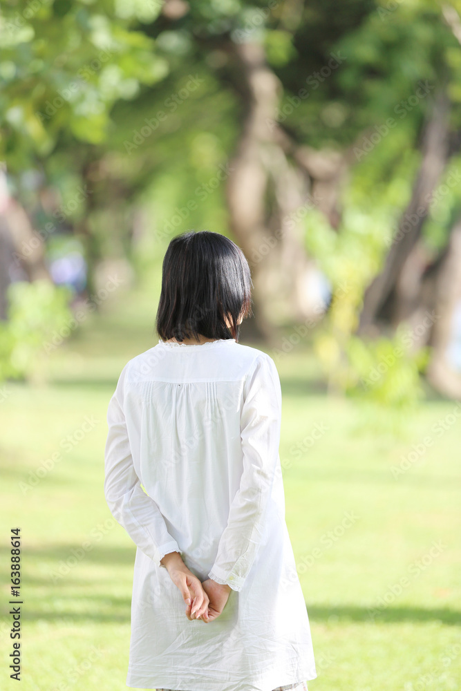 Asian young woman walk looking and traveling concept portrait with green tree background Asian young woman walk looking and traveling concept portrait with green tree background