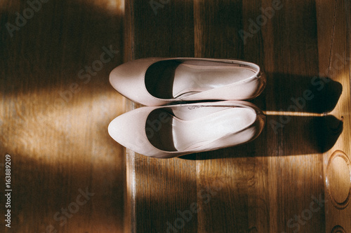 Bride wedding shoes with high heels and silver brilliant earrings on sheep's clothing