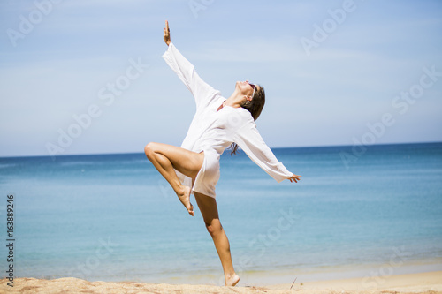 A beautiful woman with relaxing position on the beach in summer