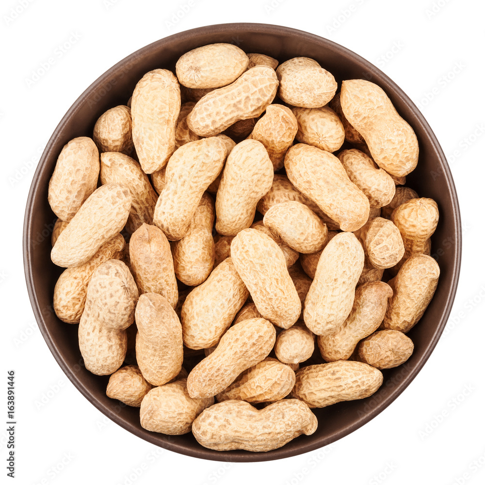 Unpeeled peanuts in ceramic bowl closeup, top view Unpeeled peanuts in ceramic bowl closeup, top view