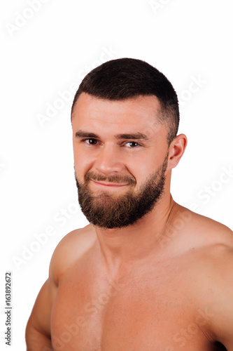 Portrait of a strong bearded male fitness model, torso. White background, isolate. hands on his hips.