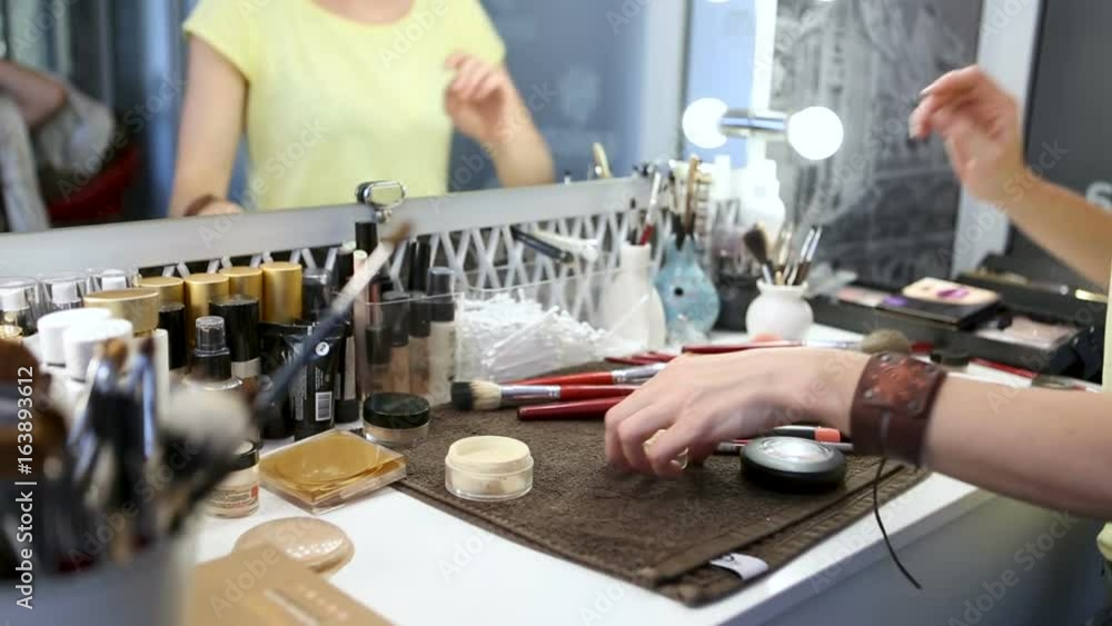 Make-up artist at work. Working visagist. Cosmetic tools. Colorful cosmetics and brushes on table. Cosmetic set on light dressing table. Beauty and makeup concept. Make-up artist at work. Working visagist. Cosmetic tools. Colorful cosmetics and brushes on table. Cosmetic set on light dressing table. Beauty and makeup concept.